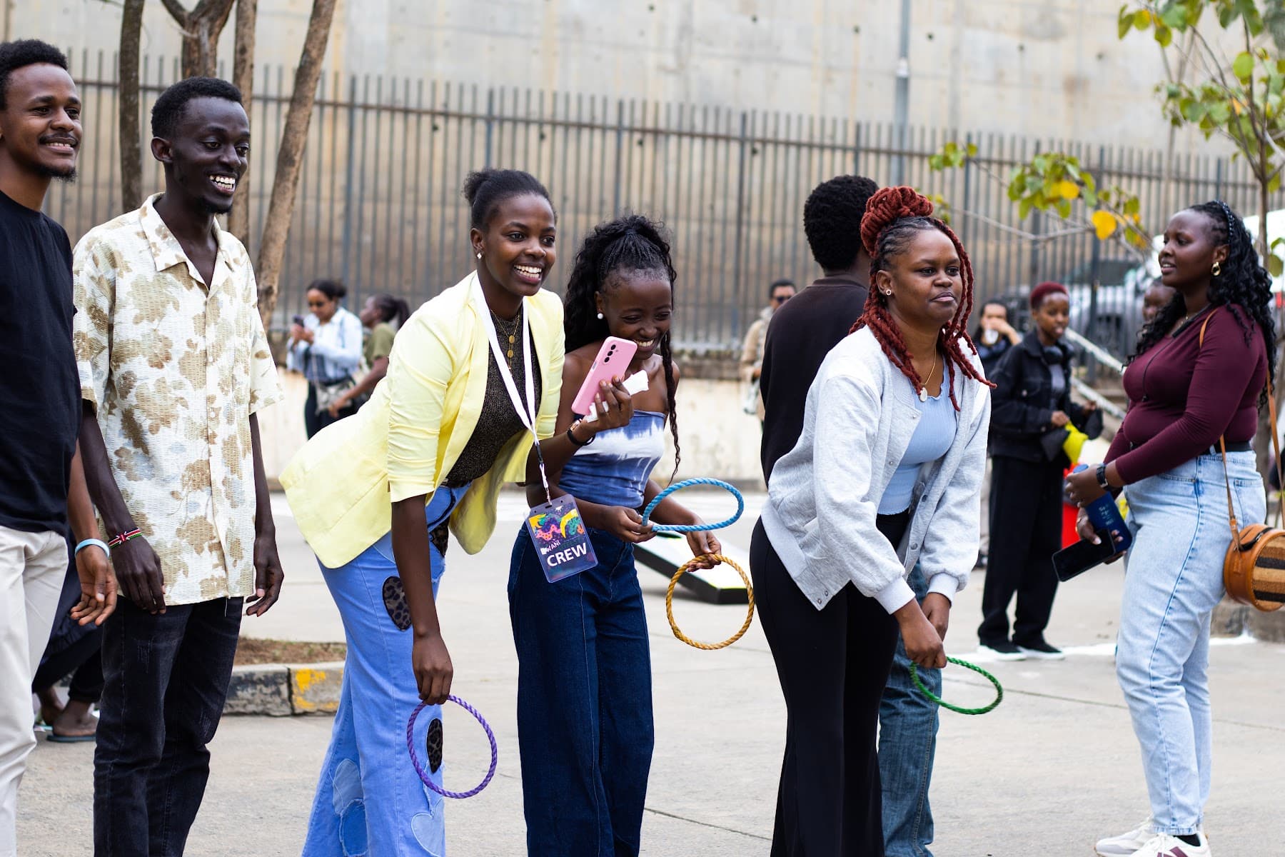 Attendees laughing as they play a ring-toss game in the courtyard